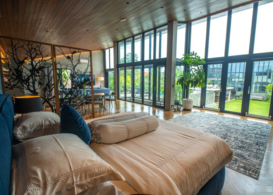 View from a bed looking out to the garden through floor to ceiling windows